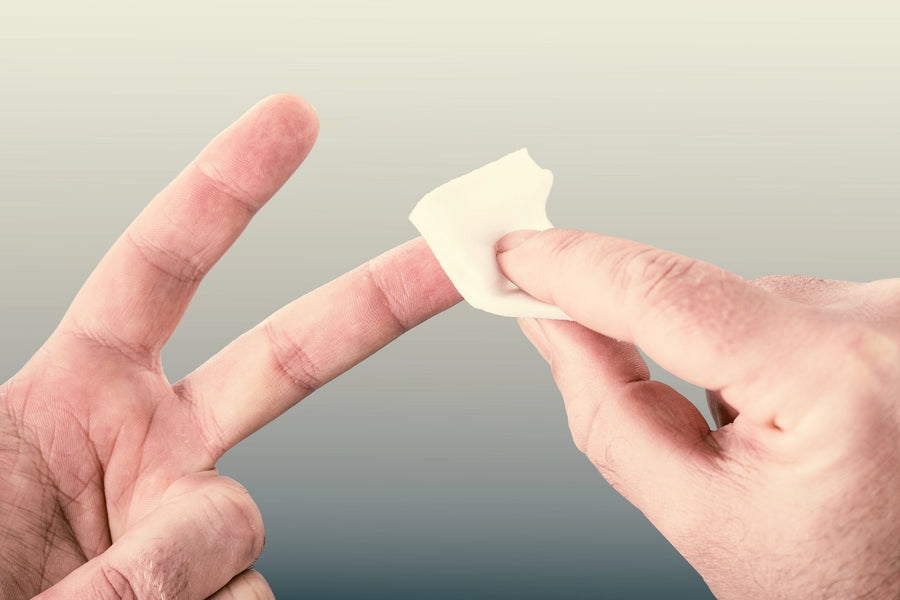 Fingerbeere wird mit einem Tupfer desinfiziert